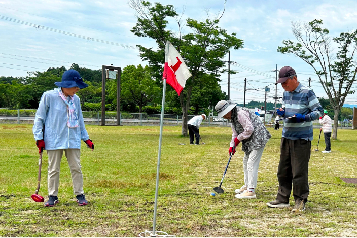 グラウンド・ゴルフ大会でボールを打つ参加者